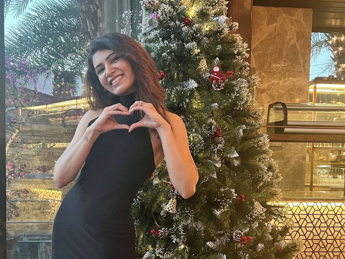 Premium Photo | The girl poses and takes a selfie near the christmas tree.  a woman congratulates a relative online by phone. she is holding a gift in  her hand and smiling.